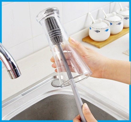 Siliconen borstel met handvat om glazen schoon te maken met hand en wasbak glas op de kop